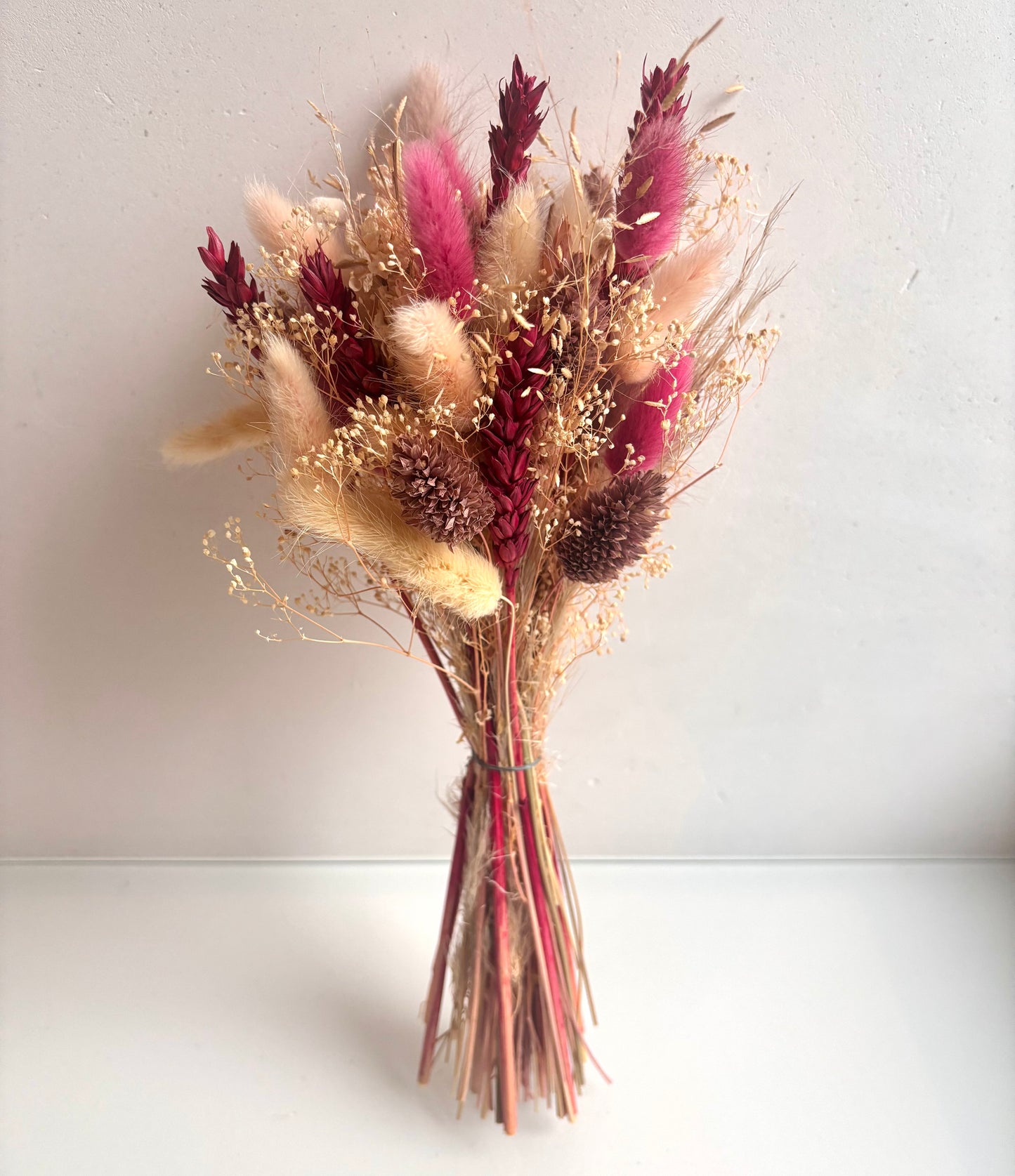 OK - Droogbloemen boeketTotale lengte boeket: 32cmPrijs: €19,90Voorraad: 1 Kleuren: wit, fuschia, oudroze, lichtroze. Soorten: lagurus, tarwe, phalaris, details sprieten beige