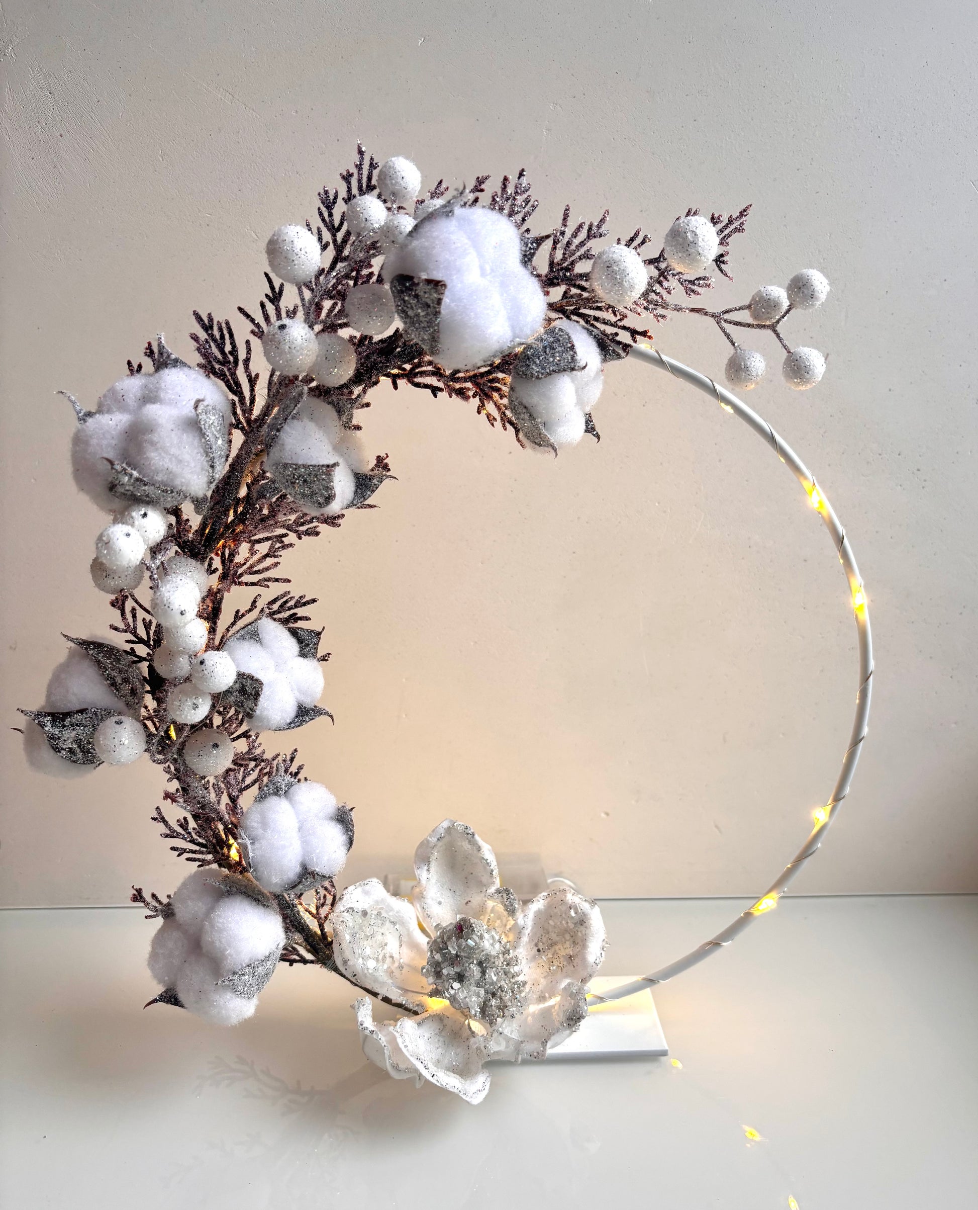 OK - Metalen witte ring met kunstbloemen, glitter en verlichting.
Kleuren: Wit/roze
Verlichting: warm wit led
2xAA batterijen, exclusief batterijen 

Diameter cirkel: 25cm
Prijs: €24,90
Voorraad: 1