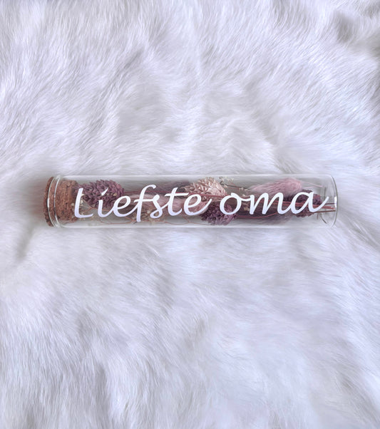 OK - Glazen buisje met kurk
Oudroze en lichtroze droogbloemen
Tekst: Liefste oma wit
B 15cm 
D 3cm
Prijs: €6,50
Voorraad: 1