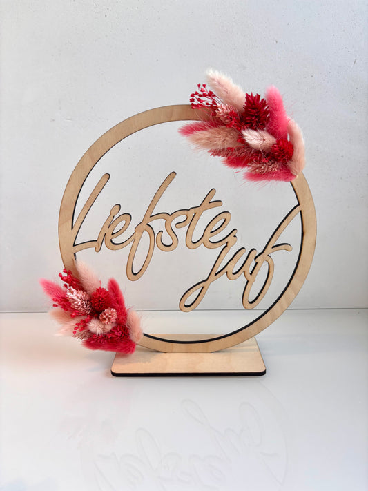 OK - Houten naamcirkel met liefste juf
Aan 2 zijden droogbloemen met felroze en lichtroze 
Diameter 20cm met staander
Voorraad: 1