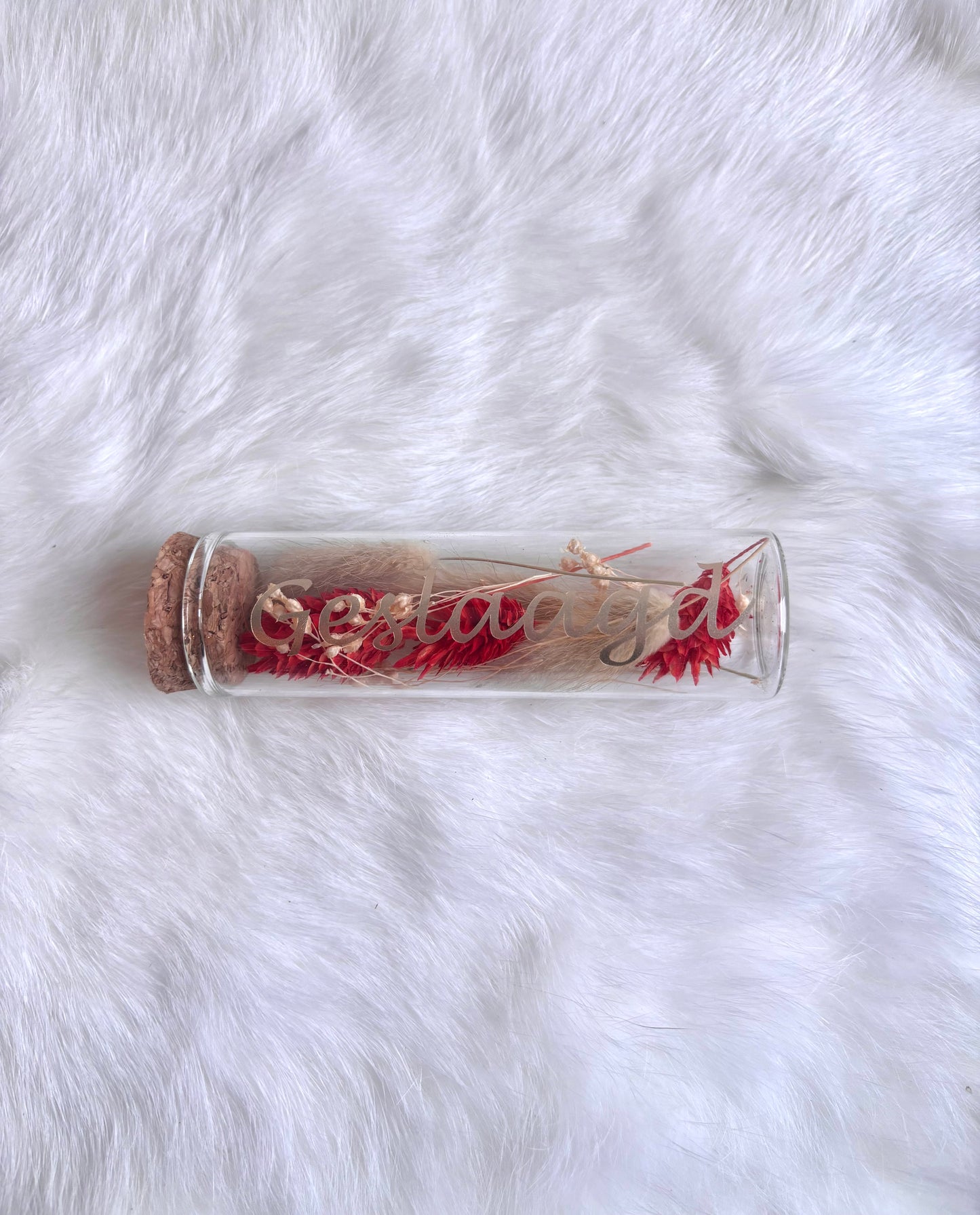 OK - Glazen buisje met kurk
beige en rode  droogbloemen
Tekst: geslaagd goud
B 10cm 
D 3cm
Prijs: €5,50
Voorraad: 1